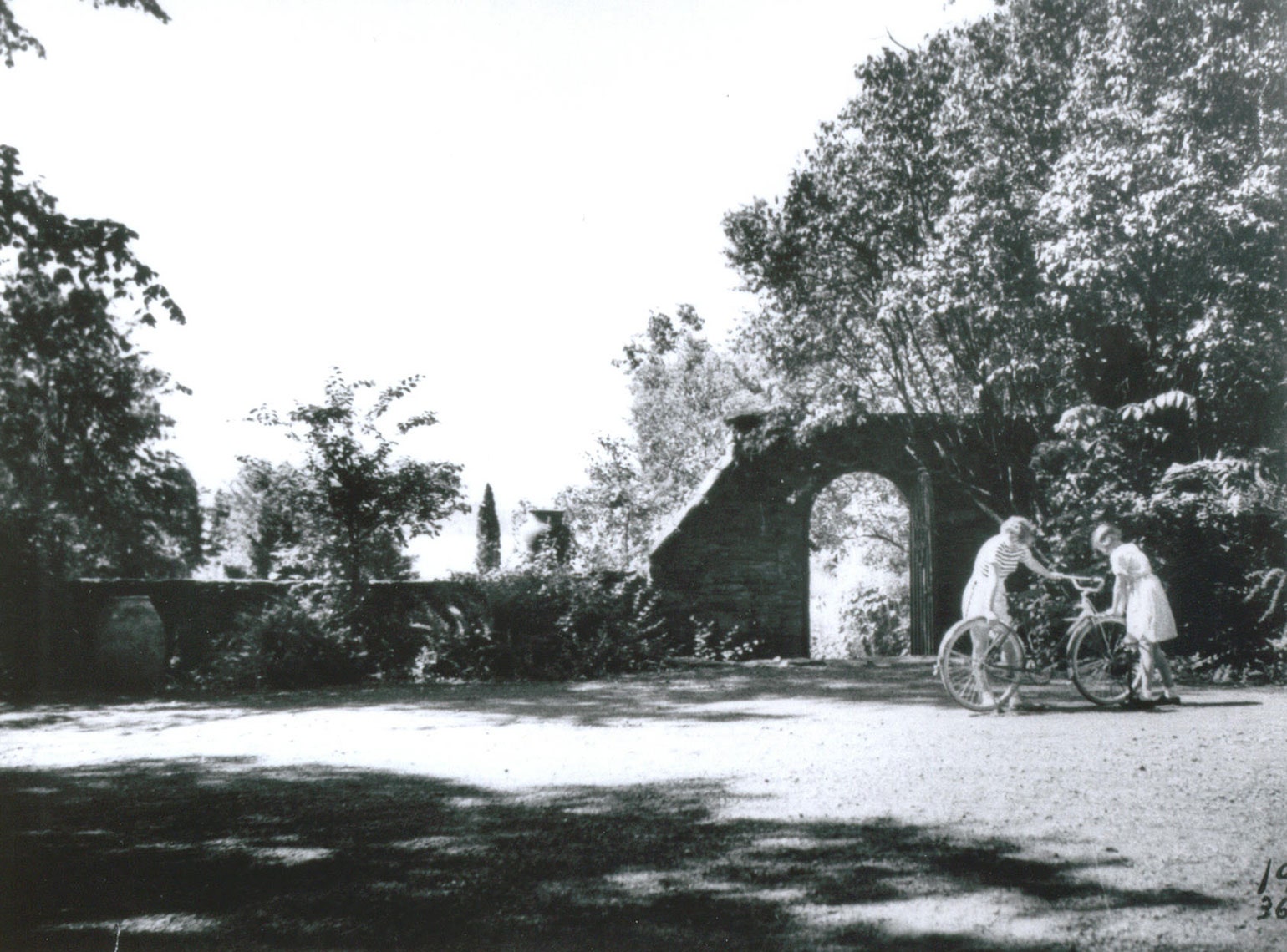 An arched door provides access to the garden from the carriage court as seen in a 1930s photograph. Archive imagery...