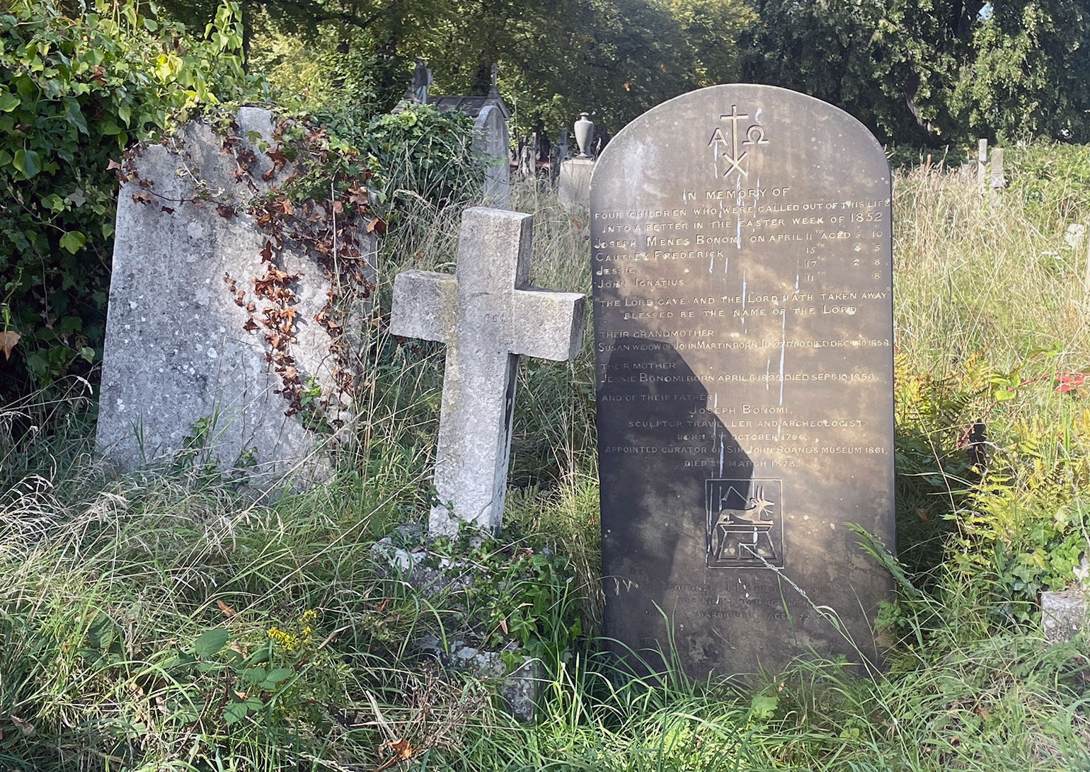 Egyptologist Joseph Bonomis own grave is austere a simple headstone lists family names and his positions. An allusion to...